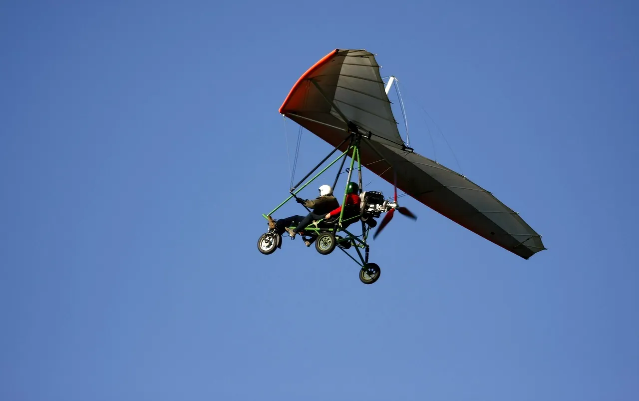 Ailes aérodynamiques, harnais simplifiés, nageoires flottantes, fond bleu ciel, figure montante contre les courants d'air, scène de vol ensoleillée, pilote alimenté par l'adrénaline, formation de vol dynamique, paysage aérien panoramique