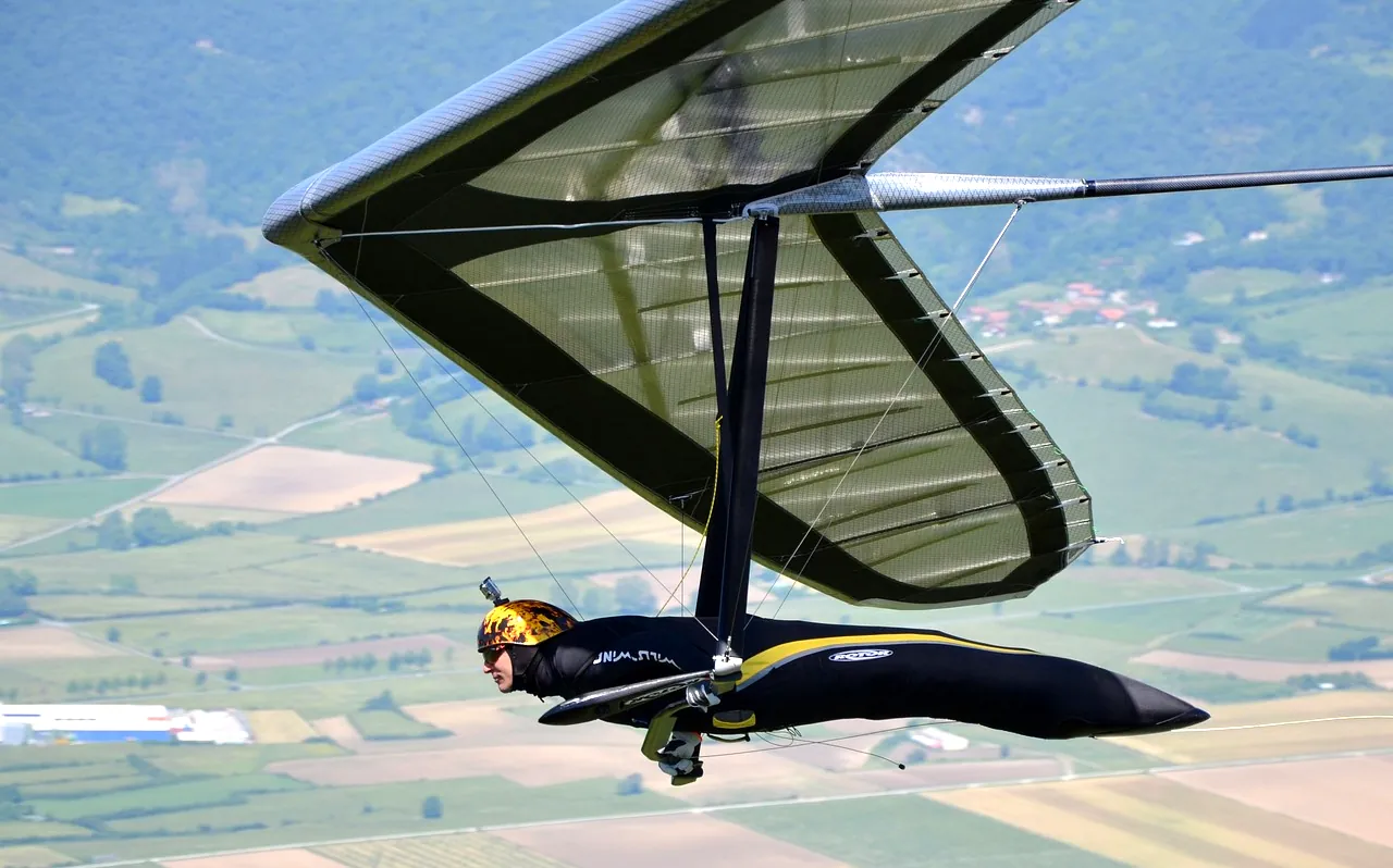 Pilotes aventuriers exploitant des courants de vent sur des ailes minces, manœuvres volantes dynamiques contre des ciels ouverts, ascension palpitante dans des brises légères, paysage serein sous une silhouette plane